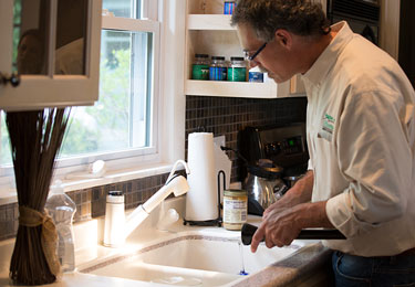 A home inspector inspecting the kitchen plumbing.